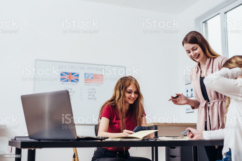 young-woman-teaching-english-to-adult-students-at-language-school-picture-id1066463004